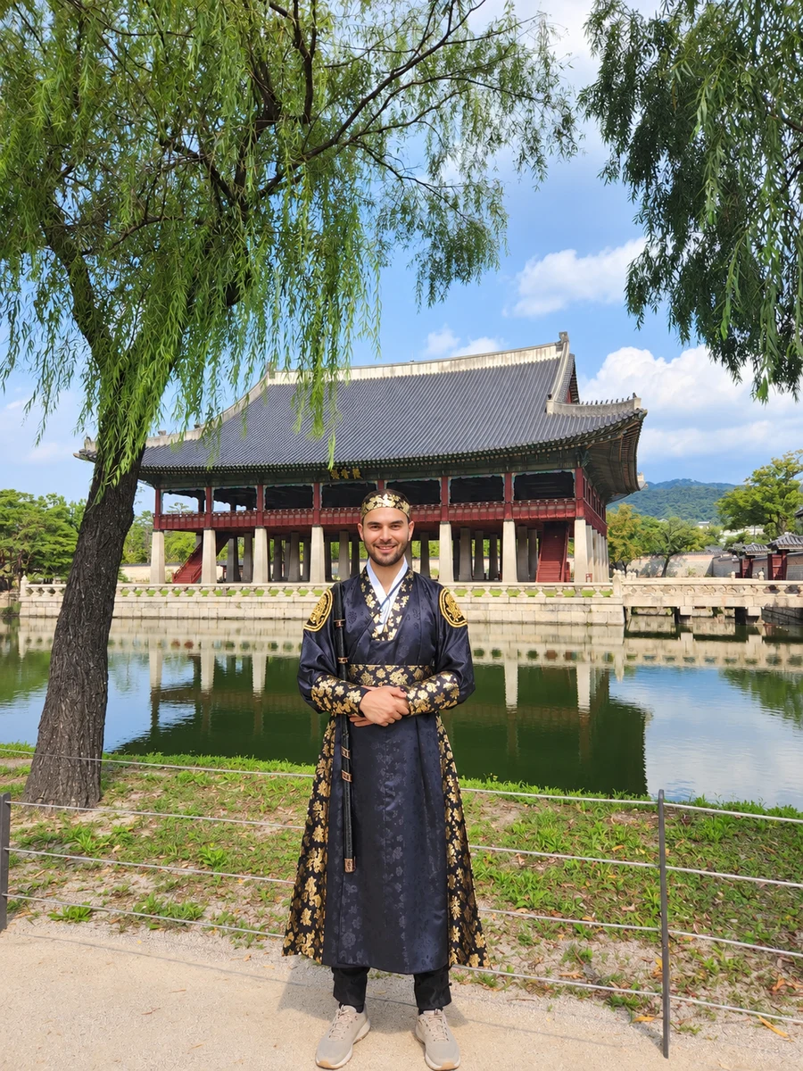 Nabil wearing a hanbok in front of a Korean palace